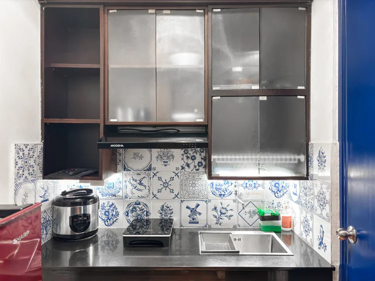 Amsterdam: Keramik motif Delft di dapur, dengan rice cooker dan kompor induksi.