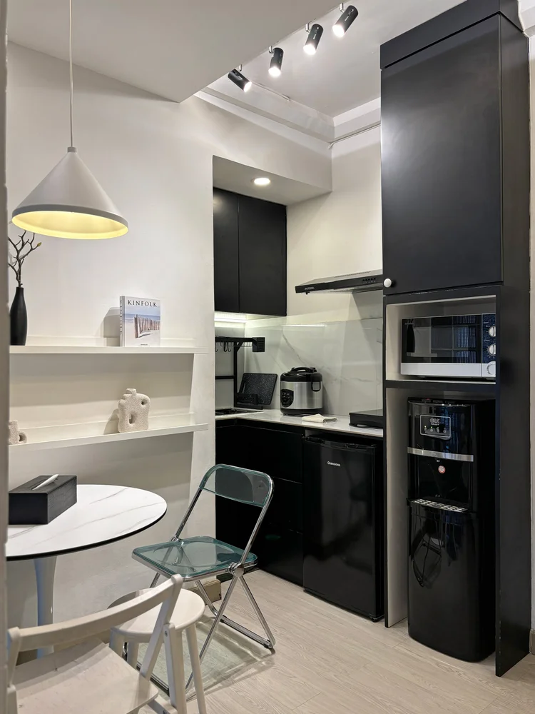 Sydney: Dapur terbuka modern serba hitam: kulkas, microwave, dan kompor induksi.