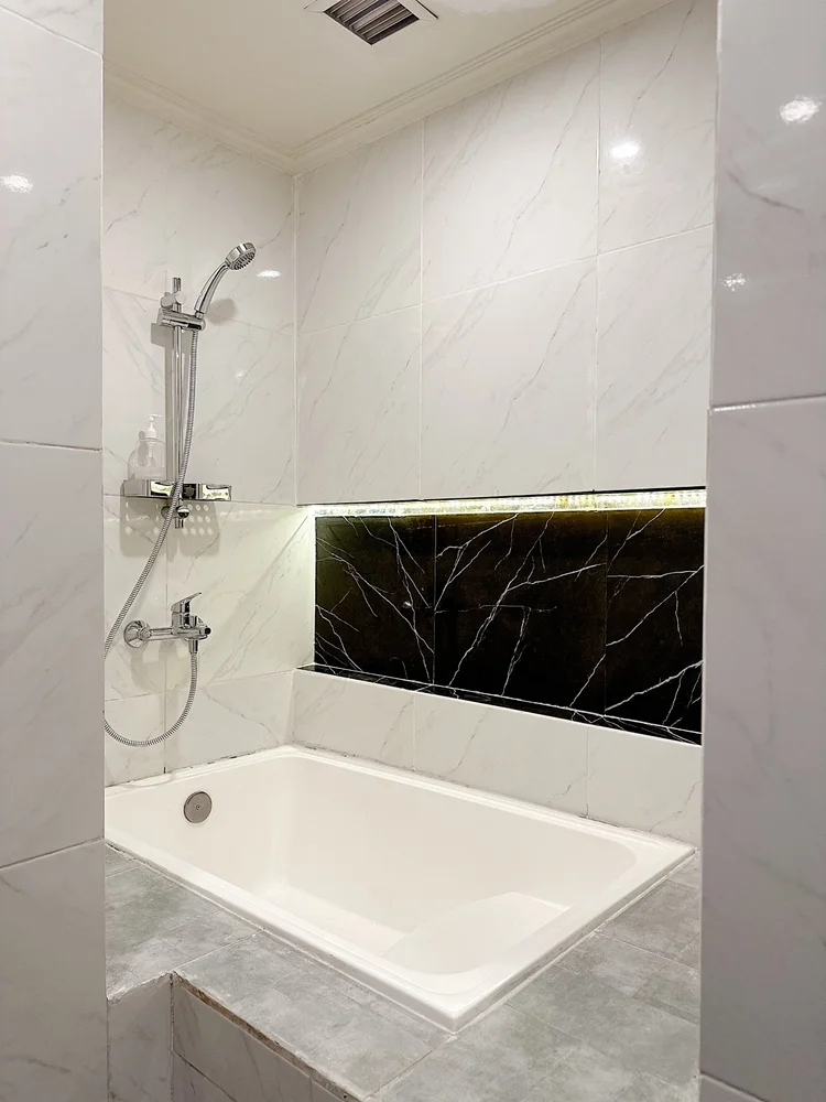 Boston: Bathtub dengan shower air panas, bernuansa marmer putih dari lantai sampai dinding.