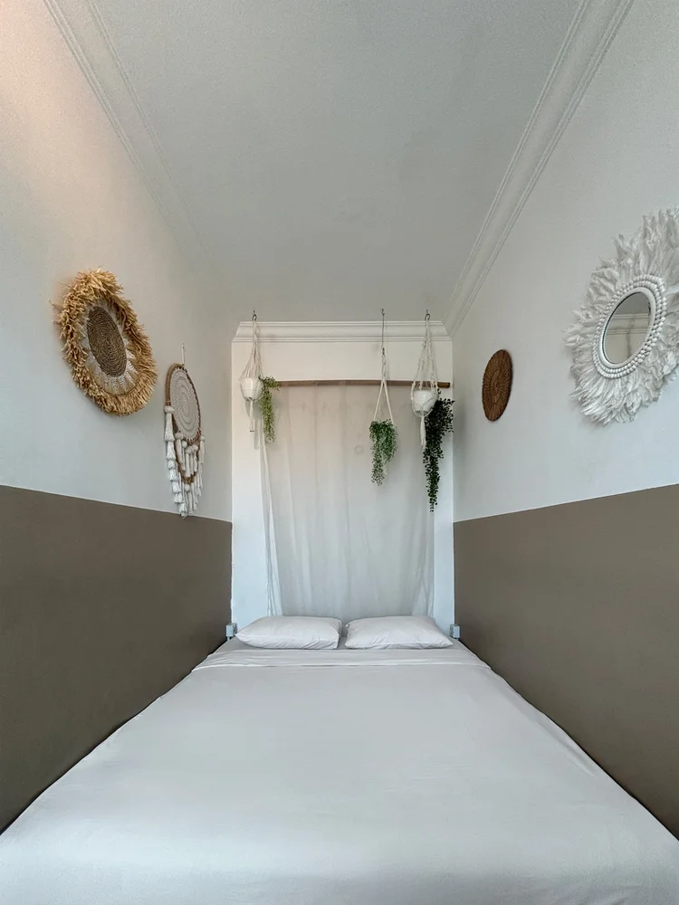 Honolulu: Kamar dengan queen bed 160 cm di lantai, kelambu tipis, dan cermin anyaman.