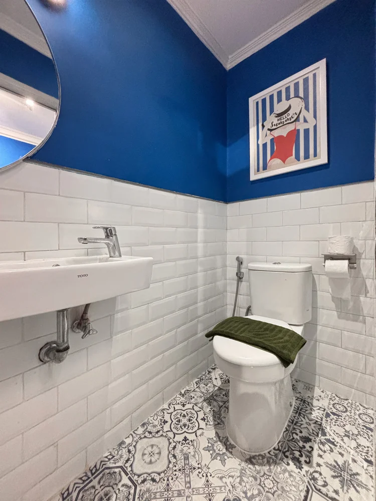 Santorini: Kamar mandi kecil di kamar ranjang susun: wastafel dan toilet, dinding biru.