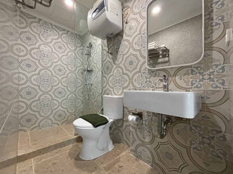 Mykonos: Kamar mandi dengan shower air panas dan ubin bermotif.