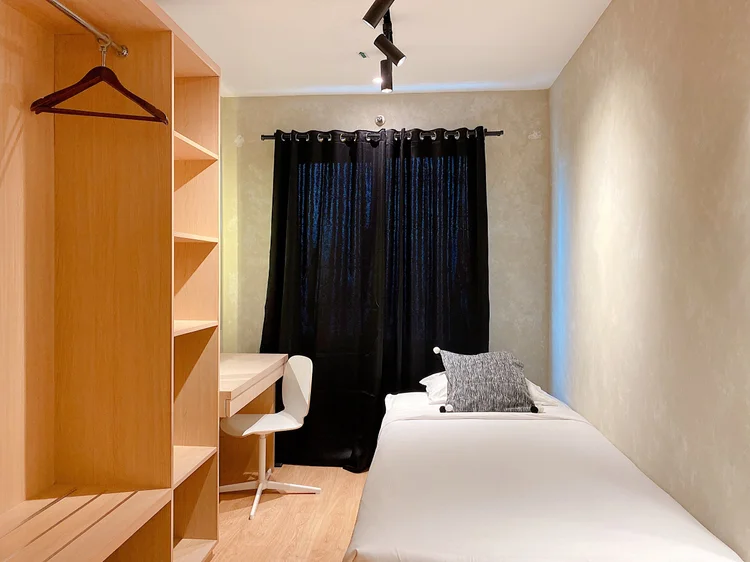 Amalfi: Single bed dengan lemari terbuka dan meja sendiri, nyaman untuk satu orang.