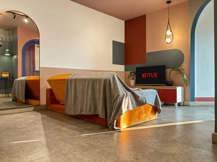 Geneva: Tempat tidur dengan seprai mustard, dengan smart TV Netflix terlihat dari kamar.