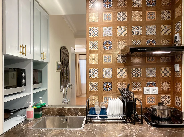 Batavia: Dapur terbuka dengan kompor induksi, microwave, rice cooker, dan alat masak dasar.