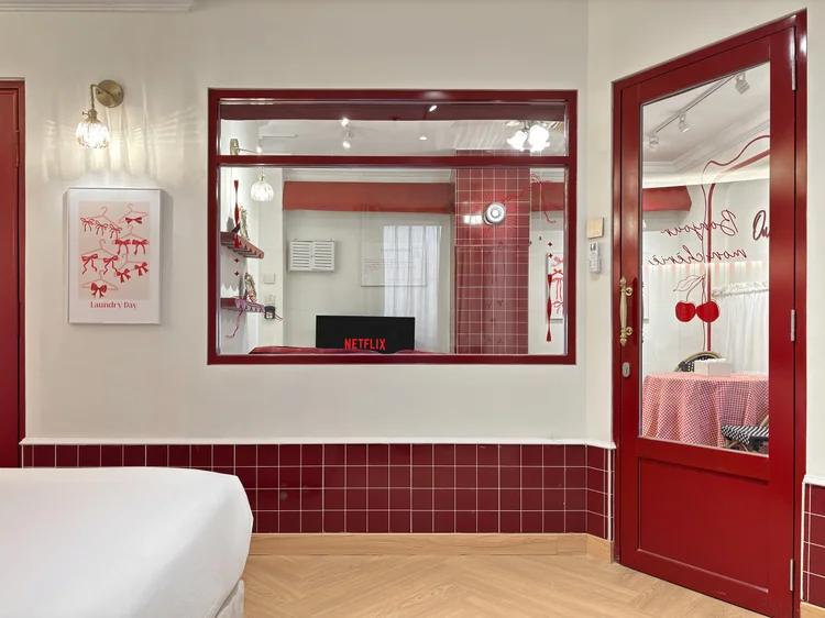 Chamonix: Smart TV dengan Netflix menghadap tempat tidur, dengan cermin dan pintu merah di sebelahnya.