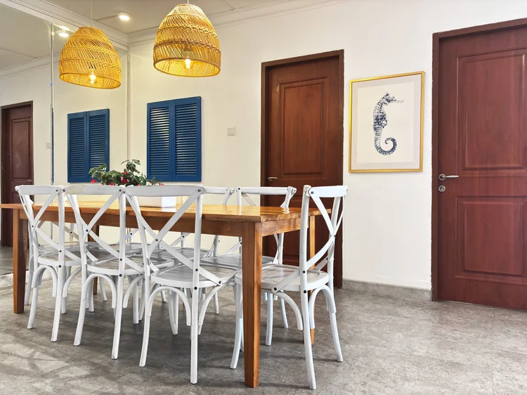 Santorini: Kursi putih bersilang dan lampu gantung rotan di atas meja makan.