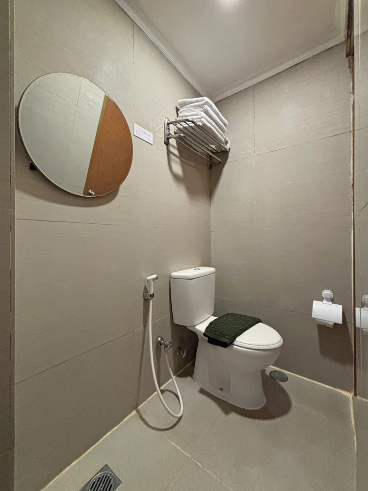 Panama: Kamar mandi dengan toilet dan cermin; sabun dan sampo sama di semua unit.