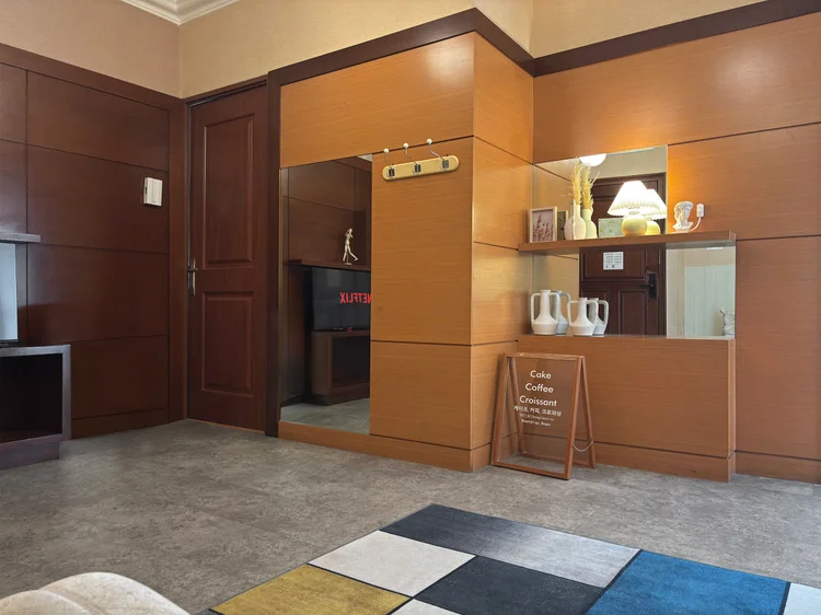 Busan: Panel kayu dan papan menu kecil di pintu masuk, suasana kafe sejak langkah pertama.