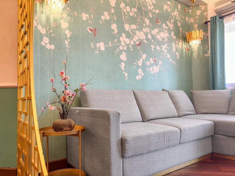 Salzburg: Sofa empat dudukan di depan wallpaper bunga sakura, tempat kumpul setelah jalan seharian.