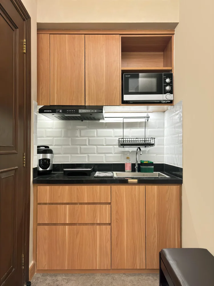 Nakameguro: Dapur terbuka dengan microwave, kompor induksi, dan kabinet kayu.