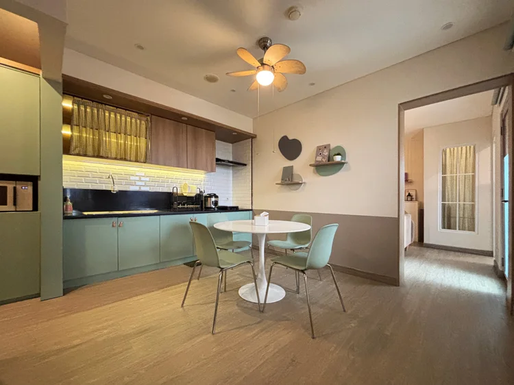 Seoul: Area makan dengan kipas angin langit-langit, dapur terbuka besar di sampingnya.