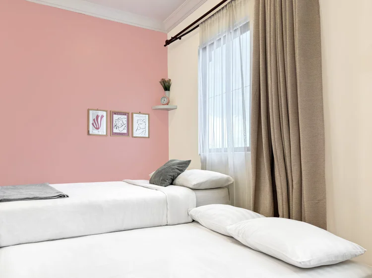 Milan: Kasur sliding ditarik keluar jadi dua kasur berdampingan; sprei putih seperti di semua unit kami.