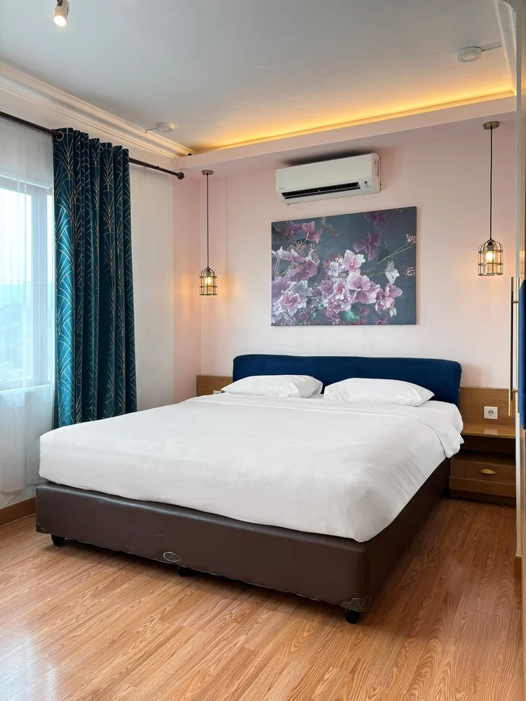 Beverly: Kamar yang sama dilihat dari sisi jendela, terang oleh cahaya siang.