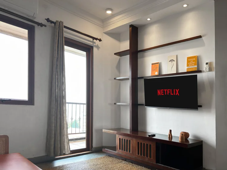 Ubud: Ruang tamu dengan pintu ke balkon dan smart TV dengan Netflix di rak dinding.