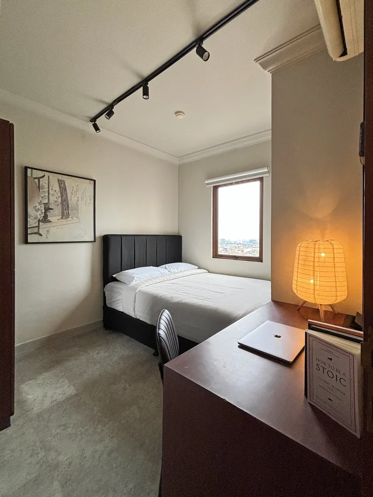 Saitama: Sudut kamar dengan meja dan lampu hangat, tempat menaruh barang sebelum tidur.
