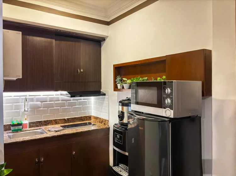 Norfolk: Dapur terbuka dengan microwave, kulkas, dan dispenser; tiap unit punya galon cadangan.