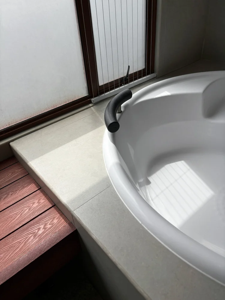 Okinawa: Private indoor onsen dengan lantai kayu di tepinya, detail khas Okinawa.