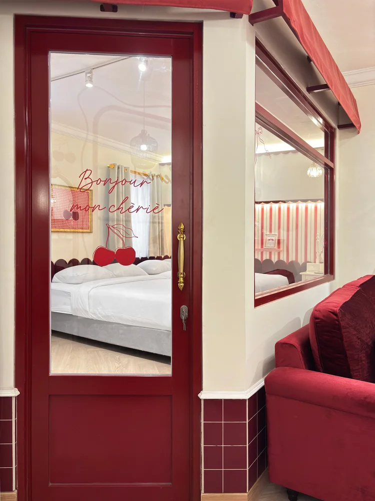 Chamonix: Pintu merah di antara kamar tidur dan ruang keluarga bersofa merah.
