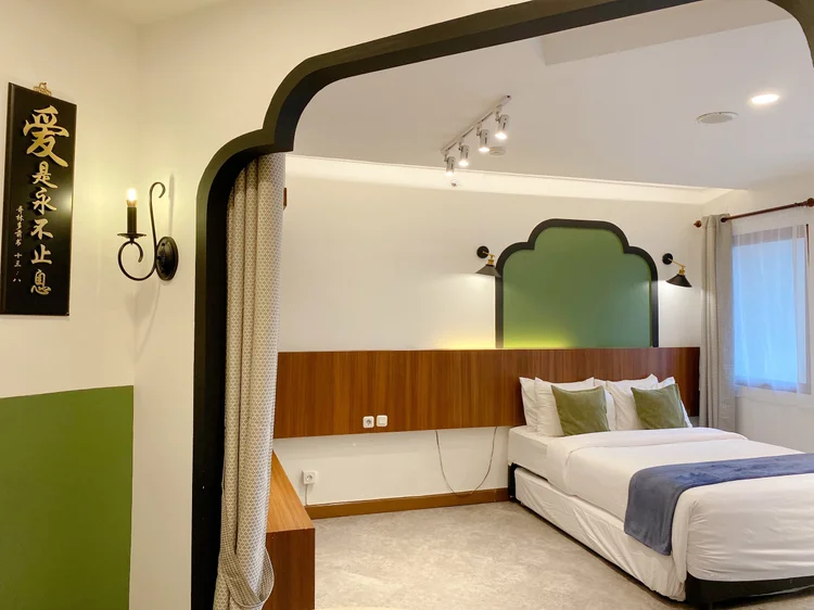 Saigon: Kaligrafi dan lengkungan hijau, detail tema Peranakan Flair di area tidur.