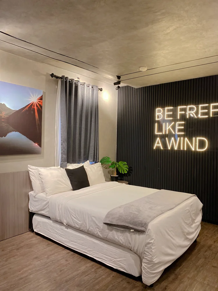Kingston: Small double bed 140 cm di bawah neon, sprei putih seperti di semua unit kami.