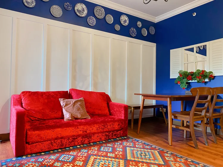 Amsterdam: Tema Dutch Blue Red: dinding biru, sofa merah, dan piring Delft di unit untuk 6 orang.